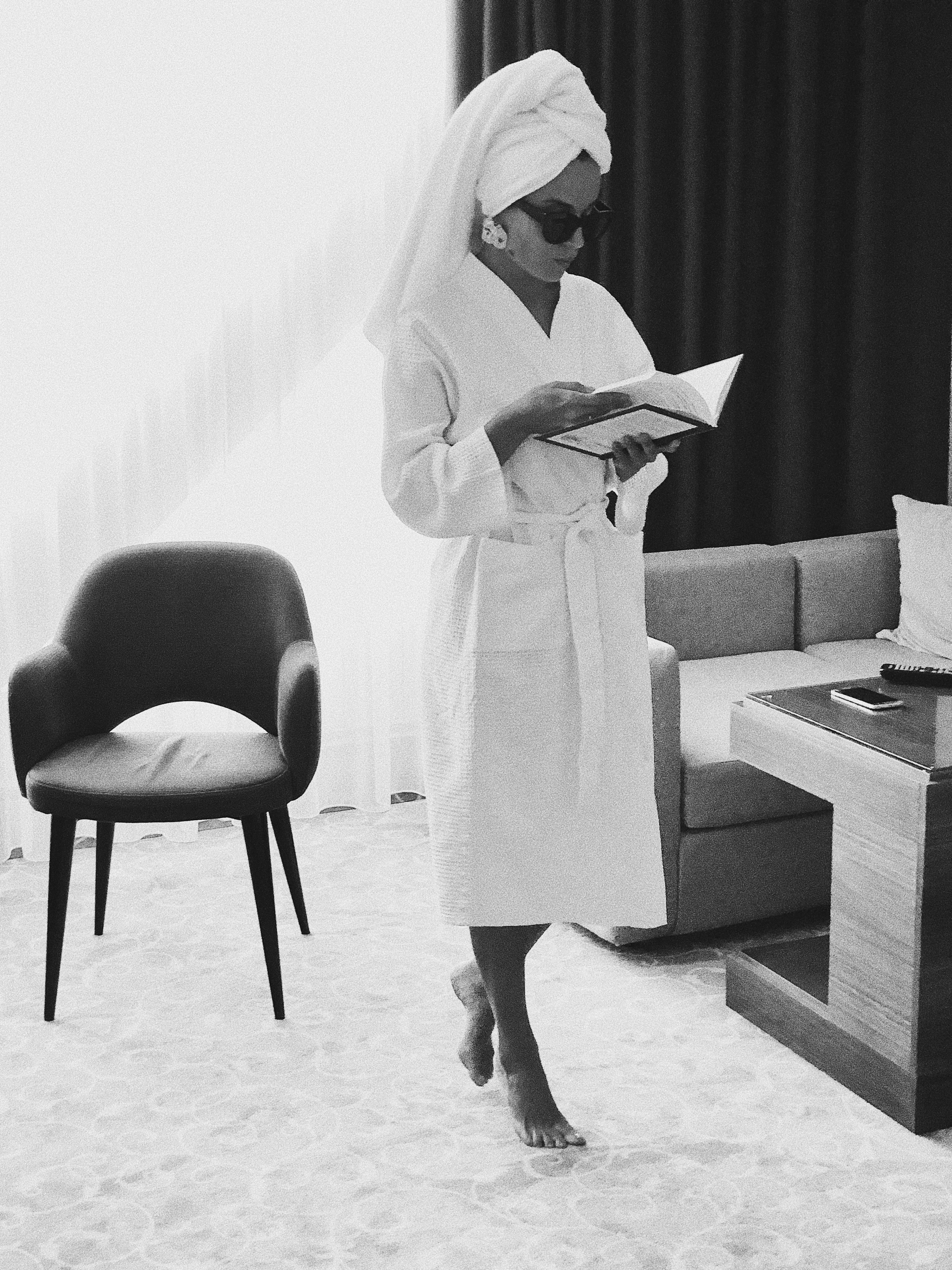 A Woman in Bathrobe Reading a Book